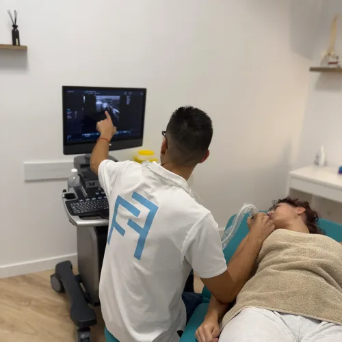 Fisioterapeuta realizando ecografía musculoesquelética en cuello y hombro en Fisio Alcantarilla, Murcia.